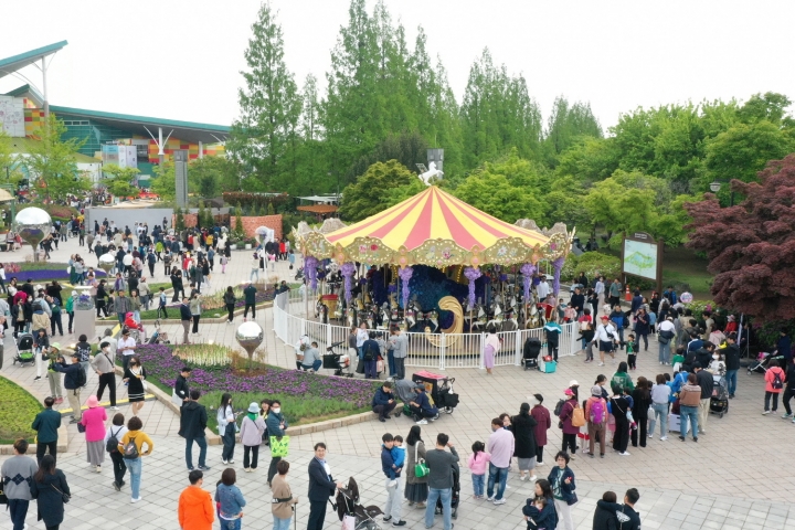 고양국제꽃박람회를 찾은 관람객들이 꽃으로 장식된 회전목마를 체험하고 있다.