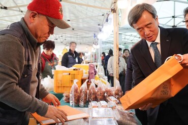 ‘바로마켓’설맞이 할인행사에서 한국마사회 정기환 회장(오른쪽)이 물건을 구입하고 있다. [사진=마사회]